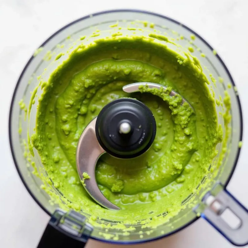 Blending ingredients for vegan pesto sauce