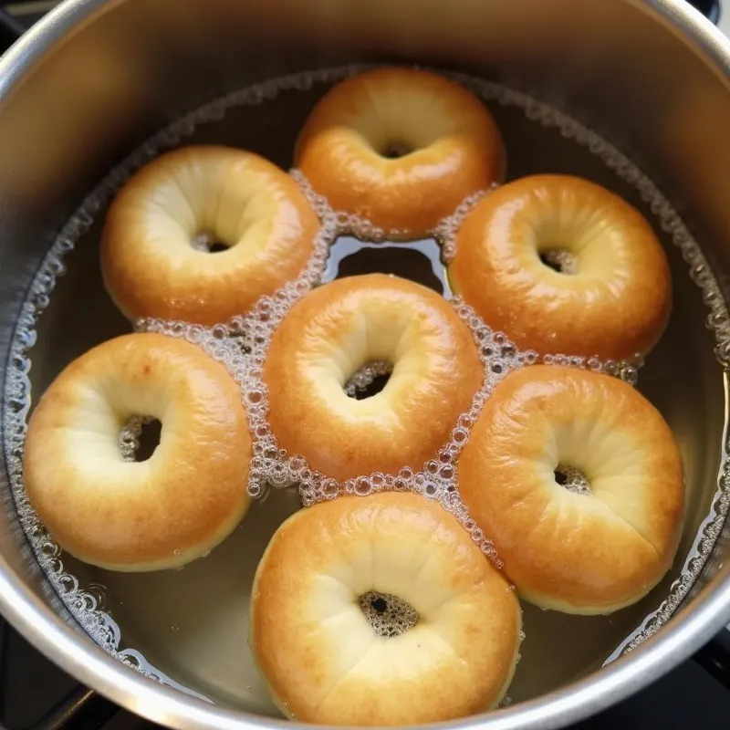 Boiling vegan bagels in a pot of water