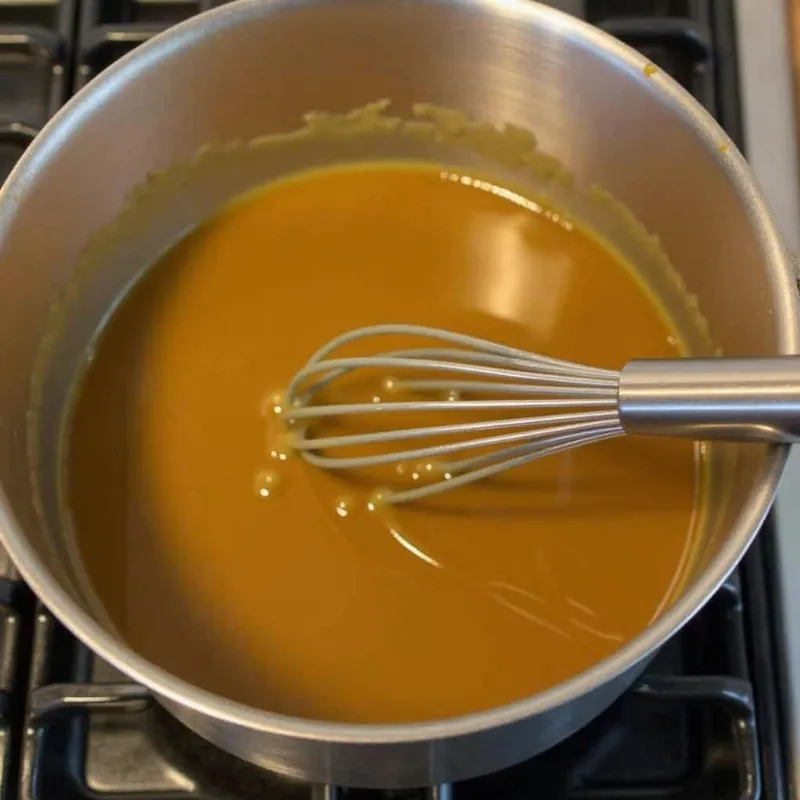 A pot of vegan gravy being reheated on the stovetop.