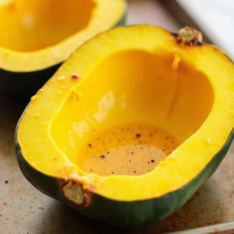 Roasted acorn squash halves on a baking sheet