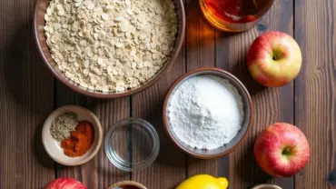 Vegan apple crumble ingredients arranged on a rustic wooden table.