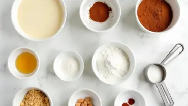 Vegan cinnamon bun ingredients arranged on a marble countertop