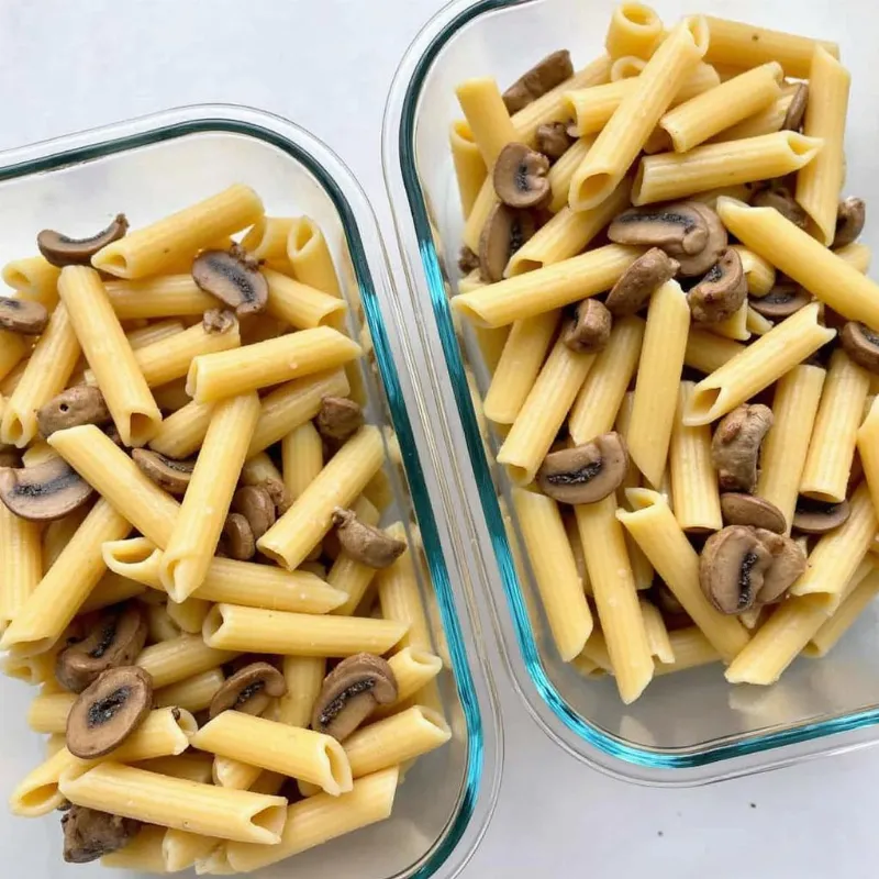 Individual portions of vegan creamy mushroom pasta in meal prep containers