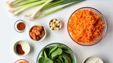 A flat lay of various fresh vegetables and spices arranged on a table