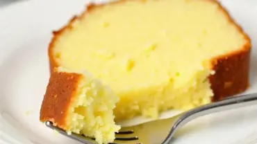 Slice of vegan lemon pound cake on a plate with a fork