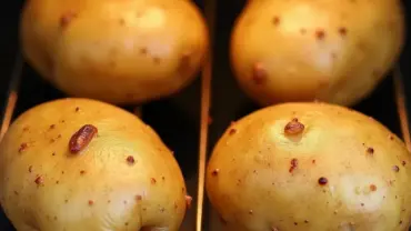 Perfectly baked potatoes on an oven rack