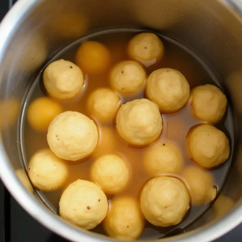 Vegan matzo balls cooking in simmering soup