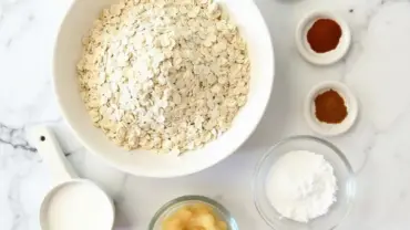 Ingredients for vegan oat bundt cake laid out on a marble countertop.