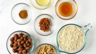 Vegan oat granola bar ingredients arranged neatly in bowls