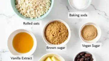 Vegan oatmeal raisin cookie ingredients laid out on a marble countertop.