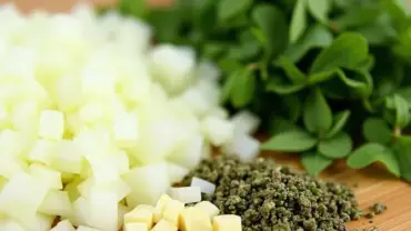 Freshly chopped onions, garlic, and herbs for vegan pasta sauce