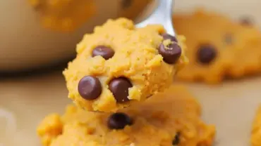 Vegan pumpkin chocolate chip cookie dough being scooped onto a baking sheet