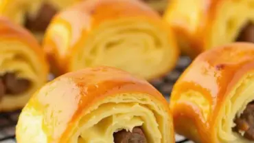 Vegan Sausage Rolls: Golden brown puff pastry filled with savory vegan sausage.