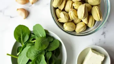 Ingredients for vegan spinach artichoke dip arranged on a wooden table