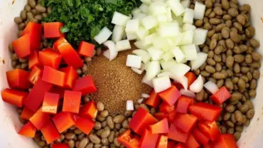 A close-up shot of the colorful vegan stuffed pepper filling in a bowl, showcasing the lentils, vegetables, and herbs.