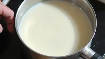 Plant-based milk warming in a saucepan on the stovetop